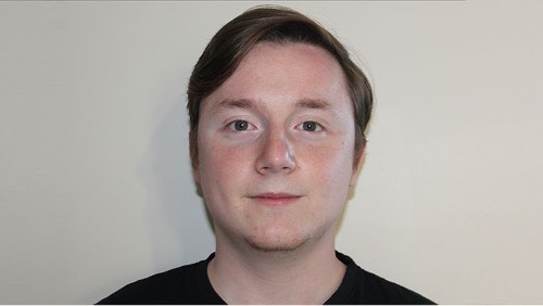 Drama student, Tom, takes a selfie against a white wall