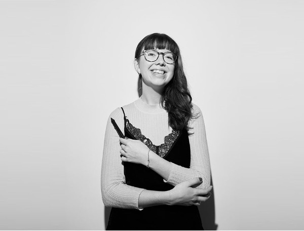 Animation student, Chloe, smiling at camera with her arms crossed