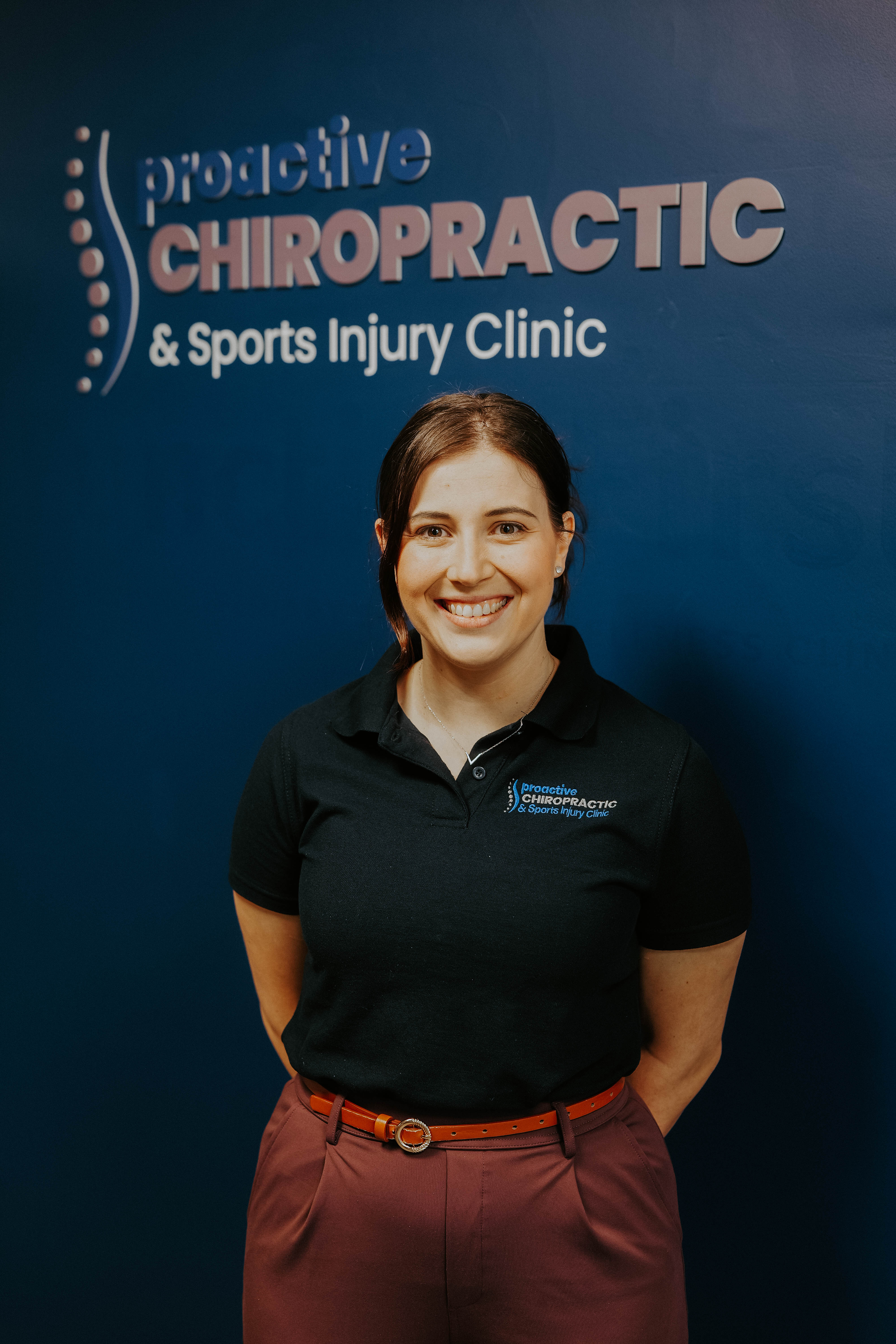 Women smiling in front of Chiropractic sign
