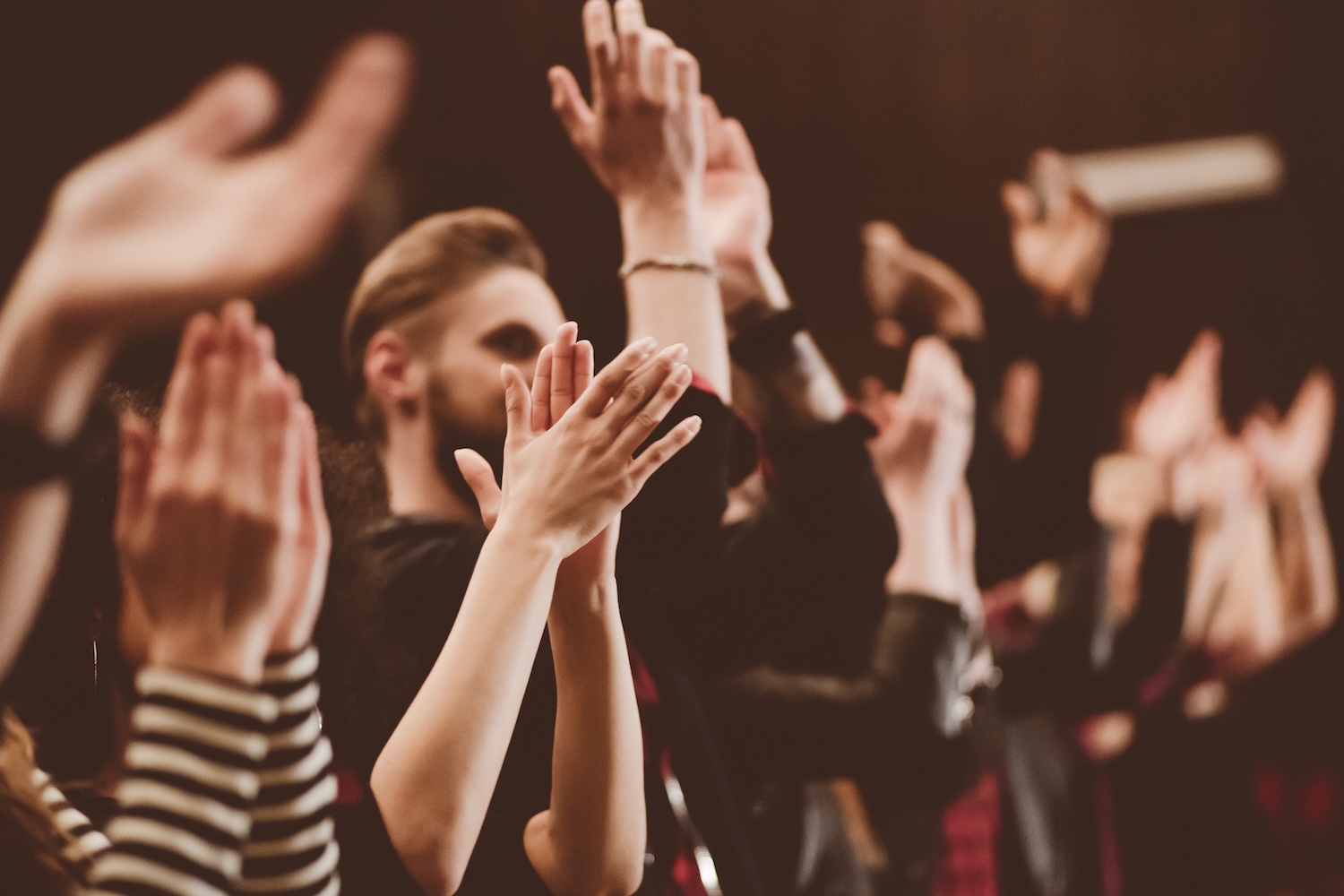 A group of people in a drama studio clapping