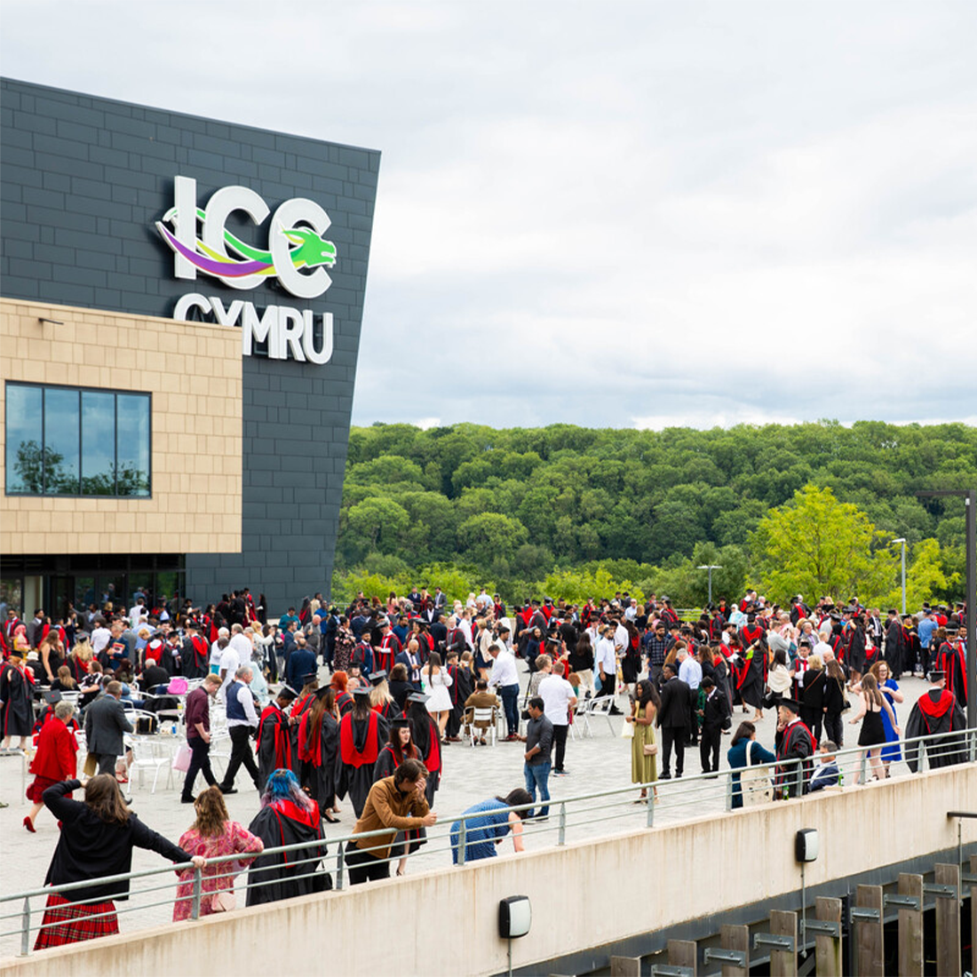 Students dressed in graduation robes and caps with their loved ones outside Newport's ICC