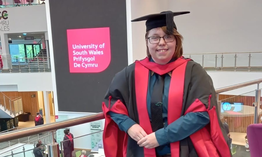 Ffydd Holbroook yn ei gwisgad graddio