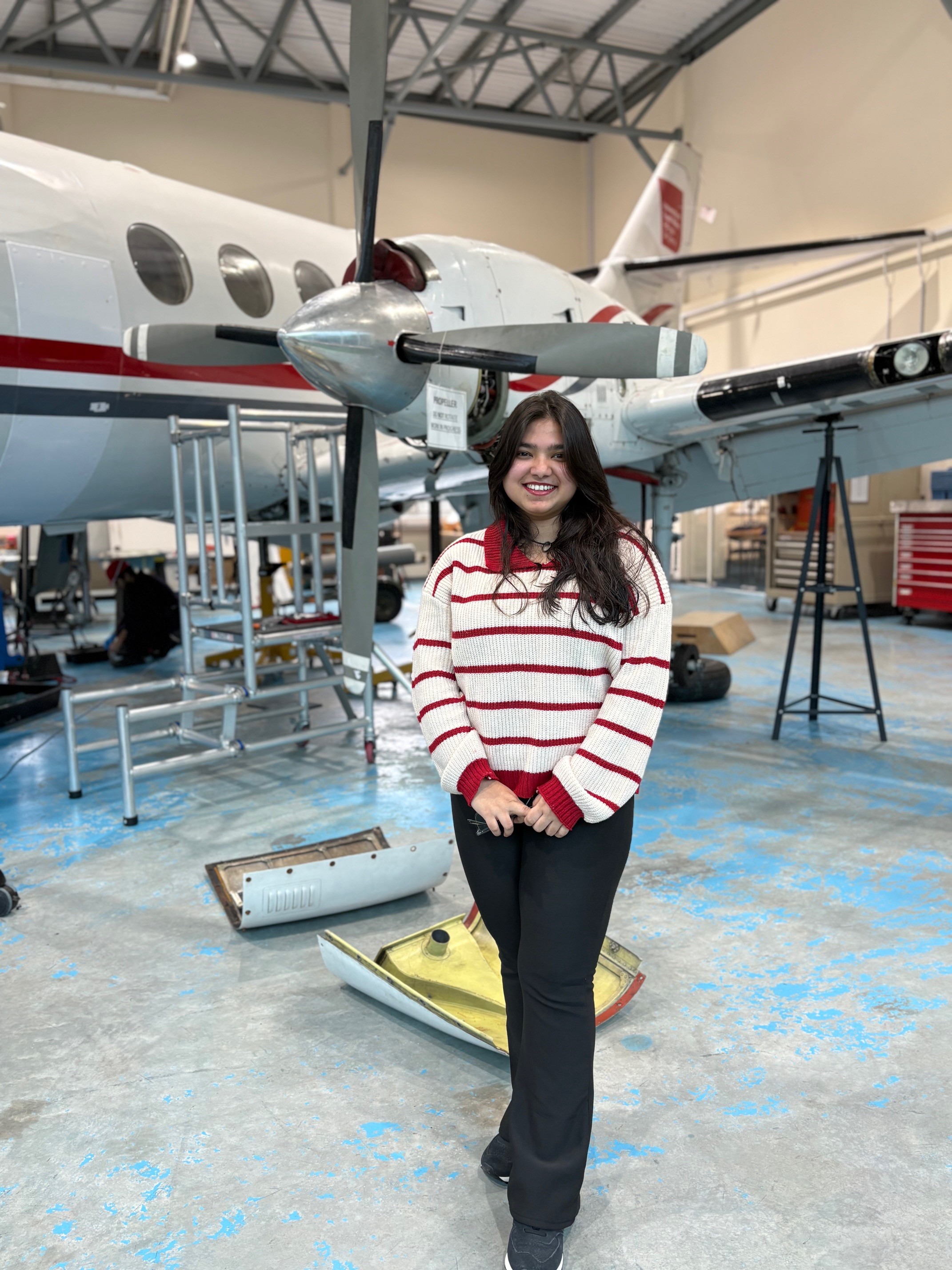 Khadijatul Kaba, in an aircraft hangar at the University of South Wales, stood in front of a propeller aircraft.